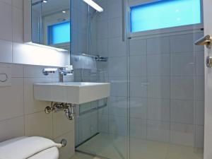 a bathroom with a sink and a glass shower at Apartment Bab-Port by Interhome in Wengen