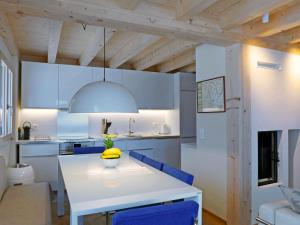 a kitchen with a white table and blue chairs at Apartment Bab-Port by Interhome in Wengen