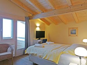 a bedroom with a large bed and a television at Apartment Bab Port Apt- 03 by Interhome in Wengen +25 photos