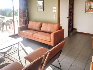 un divano marrone in un soggiorno con sedie di Holiday Home Au bord du Lac-2 by Interhome a Butgenbach