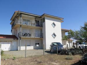 a white house with a car parked in front of it at Apartment Côte Sud-4 by Interhome in Mimizan-Plage