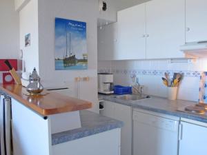 a kitchen with white cabinets and a wooden counter top at Apartment Cap Océan by Interhome in Mimizan-Plage