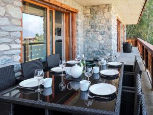 einen Tisch mit Stühlen und Gläsern auf der Terrasse in der Unterkunft Apartment Le Refuge 1 by Interhome in Nendaz