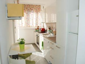 a kitchen with white cabinets and a table with a plant at Apartment App- Paradiso by Interhome in Paradiso
