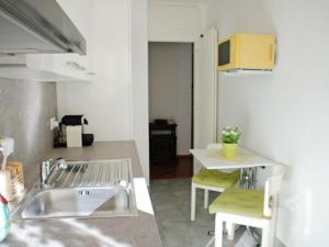 a kitchen with a sink and a table with chairs at Apartment App- Paradiso by Interhome in Paradiso