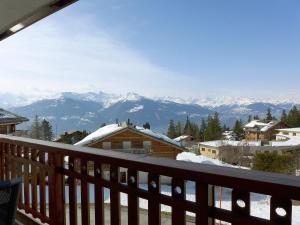een balkon met uitzicht op de met sneeuw bedekte bergen bij Apartment Les Aiguilles Vertes Rez inférieur by Interhome in Crans-Montana