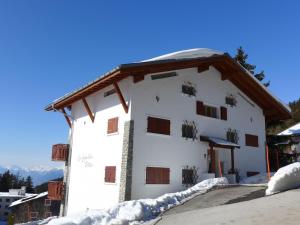 een wit gebouw met sneeuw op de grond bij Apartment Les Aiguilles Vertes Rez inférieur by Interhome in Crans-Montana