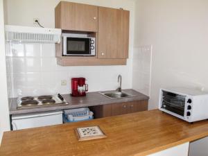 a small kitchen with a sink and a microwave at Apartment L'Oustalet-3 by Interhome in Mimizan-Plage