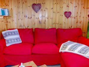 a red couch in a room with hearts on the wall at Chalet Le Ruisseau by Interhome in Nendaz +41 photos