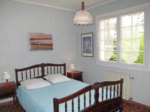 ミミザン・プラージュにあるHoliday Home Promenade des Pins by Interhomeのベッドルーム1室(ベッド1台、テーブル2台、窓2つ付)