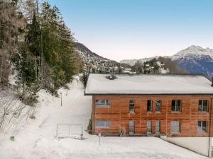 uma cabana de madeira na neve com montanhas ao fundo em Apartment Quille du Diable 44 by Interhome em Nendaz