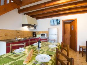 a kitchen with a table with a bottle of wine at Holiday Home Sicard-5 by Interhome in Mimizan-Plage