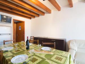 a dining room table with a bottle of wine and glasses at Holiday Home Sicard-5 by Interhome in Mimizan-Plage