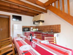 a kitchen with a red table with a bottle of wine at Holiday Home Sicard-10 by Interhome in Mimizan-Plage