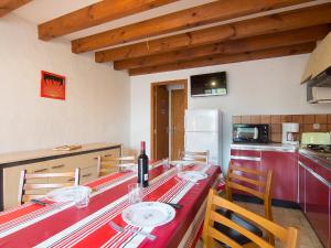 a kitchen with a red table with chairs and a refrigerator at Holiday Home Sicard-10 by Interhome in Mimizan-Plage