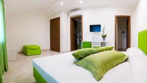 a bedroom with a white bed with green pillows at Back to Sorrento in Sant'Agnello