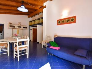 sala de estar con sofá azul y mesa en Apartment Villa Isotta-3 by Interhome, en Rosolina Mare