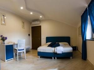 a bedroom with a bed and a desk and a chair at Back to Sorrento in Sant'Agnello