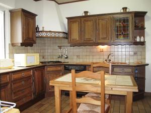 ミミザン・プラージュにあるHoliday Home Tourterelles by Interhomeのキッチン(木製キャビネット、木製テーブル付)