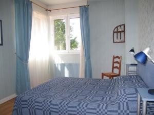 ミミザン・プラージュにあるHoliday Home Tourterelles by Interhomeのベッドルーム(青と白のベッド1台、窓付)