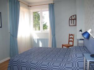 a bedroom with a blue and white bed and a window at Holiday Home Tourterelles by Interhome in Mimizan-Plage +25 photos