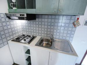 cocina con fregadero y fogones en Apartment Villa Isotta-1 by Interhome, en Rosolina Mare