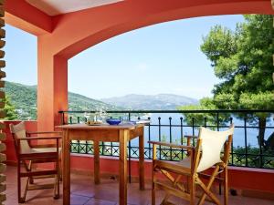a balcony with a table and chairs and a view of the water at Apartment Villas Cavo Marathia 4 Apartments by Interhome in Marathias