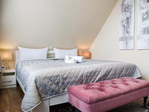 ノルトダイヒにあるApartment Witthuus-Wangerooge by Interhomeのベッドルーム1室(ベッド1台、ピンクのベンチ付)