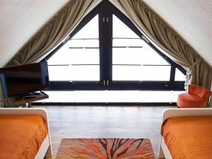 ノルトダイヒにあるApartment Witthuus-Wangerooge by Interhomeのベッド2台と大きな窓が備わる客室です。