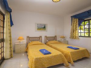 two beds in a bedroom with yellow comforter at Villa Villa Quinta do Sol by Interhome in Armação de Pêra