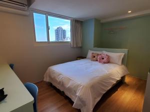 A bed or beds in a room at 小窩旅店-羅東夜巿店