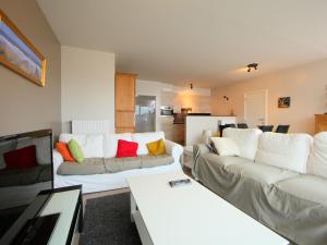 a living room with a white couch with colorful pillows at Apartment Greens 103 with parking by Interhome in Mispelburg