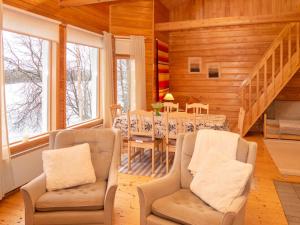 ein Esszimmer mit Tisch und Stühlen und Fenstern in der Unterkunft Holiday Home Pesäkolo by Interhome in Kiviperä