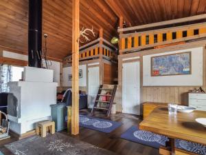 a living room with a stove and a wooden ceiling at Holiday Home Salakolo 2 by Interhome in Ruka