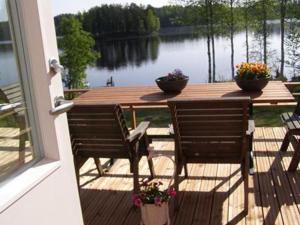 a table and chairs on a deck with a view of a lake at Holiday Home Ellilä by Interhome in Palonurmi