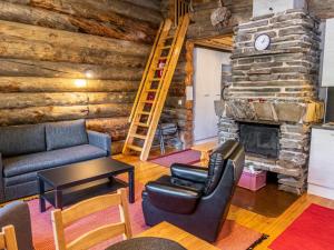ein Wohnzimmer mit Couch und Kamin in der Unterkunft Holiday Home Pajuruka 2 a 1 by Interhome in Ruka