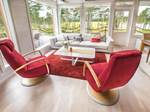 a living room with red chairs and a couch at Holiday Home Villa biegga by Interhome in Kyrö