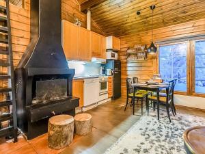 une cuisine avec une cheminée et une table avec des chaises dans l'établissement Holiday Home Lomaylläs b19 - palovaarankaarre 2 b by Interhome, à Ylläsjärvi 9 autres photos