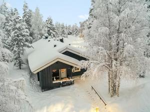 une maison recouverte de neige dans les bois dans l'établissement Holiday Home Lomaylläs b19 - palovaarankaarre 2 b by Interhome, à Ylläsjärvi
