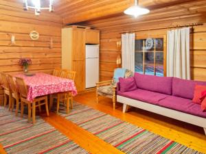 KurkimakiにあるHoliday Home Honkakoti by Interhomeの紫色のソファとテーブル付きのリビングルーム