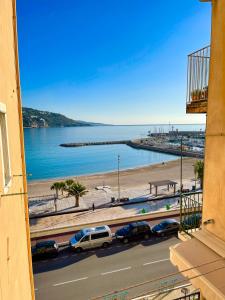 a view of a beach with cars parked on a road at Les Sablettes in Menton