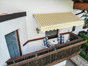 a balcony with a table and chairs under awning at Apartment Camping Rossbach-2 by Interhome in Nassereith