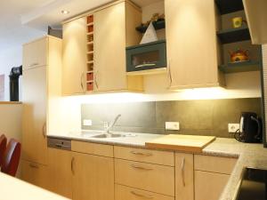 a kitchen with wooden cabinets and a sink at Apartment Camping Rossbach-2 by Interhome in Nassereith
