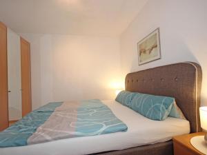 Schlafzimmer mit einem Bett mit blauer Decke in der Unterkunft Apartment Camping Rossbach-2 by Interhome in Nassereith