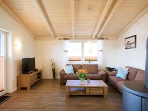 a living room with a couch and a tv at Holiday Home Langeneß by Interhome in Dagebüll