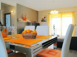 a dining room table with a basket of oranges on it at Villa Lucija by Interhome in Raša