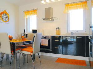 a kitchen with a table and chairs and a clock at Villa Lucija by Interhome in Raša