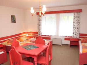 a dining room with a red table and chairs at Chalet Karlovka by Interhome in Hrabětice
