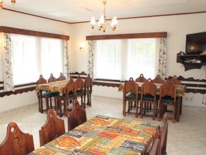 een eetkamer met tafels, stoelen en ramen bij Chalet Karlovka by Interhome in Hrabětice