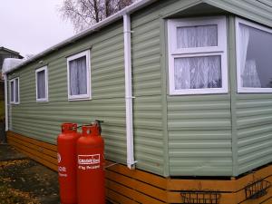 a green house with two fire hydrants in front of it at Superb luxury 2 Bedroom Double bed settee sleep six caravan in Gisburn